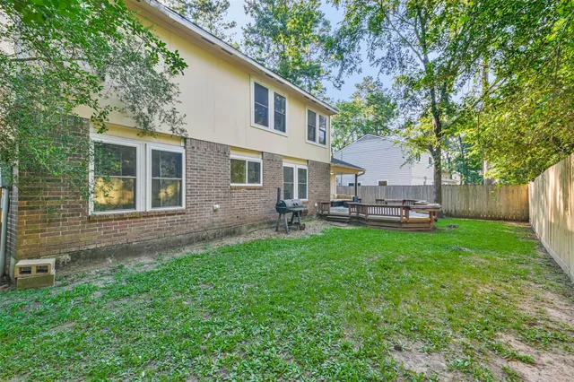 a view of a house with backyard and a tree