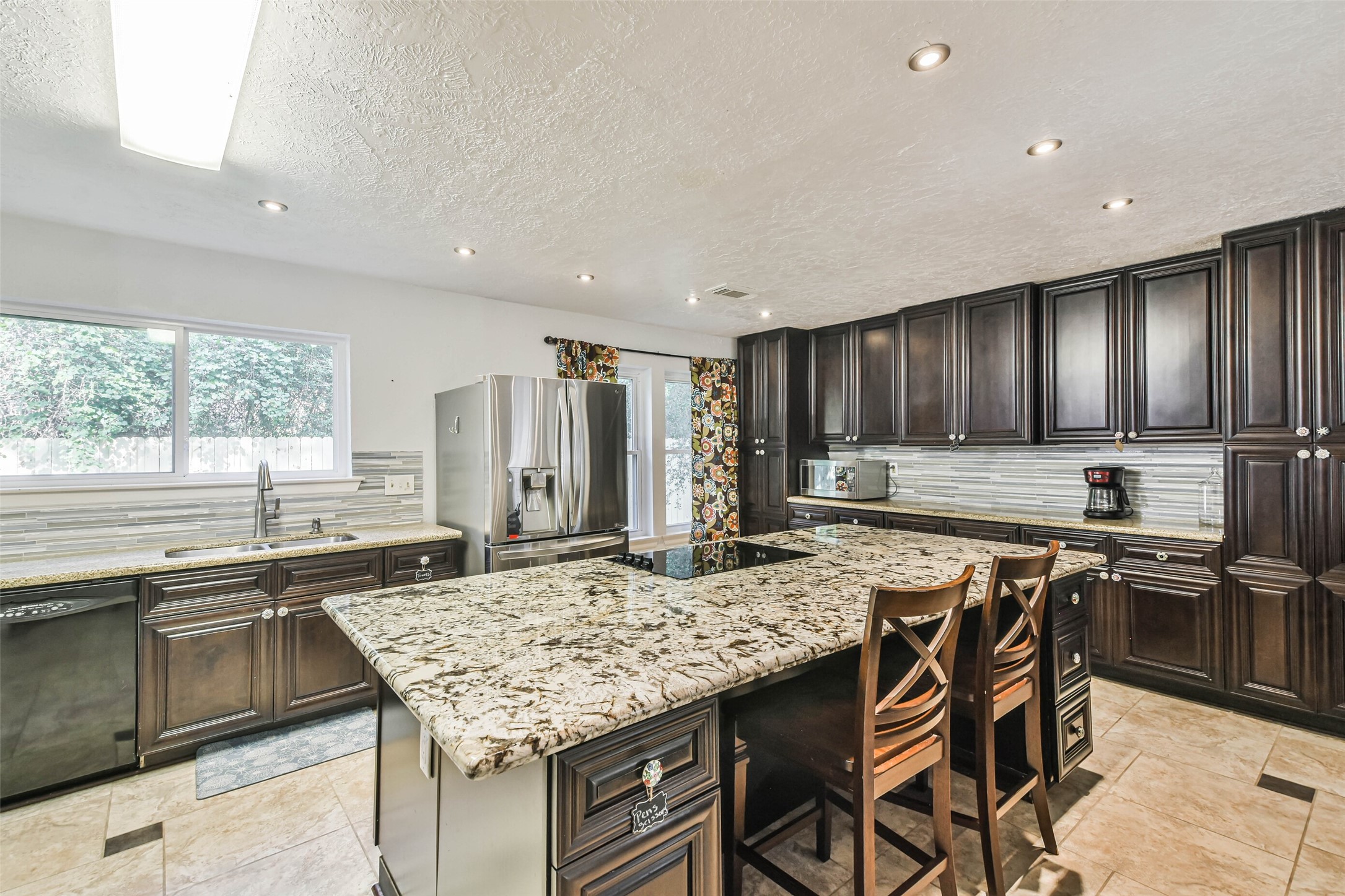 12 Coralberry Road Spring, TX 77381 - Photo 8 of 45 a kitchen with stainless steel appliances granite countertop a stove top oven a sink refrigerator and cabinets