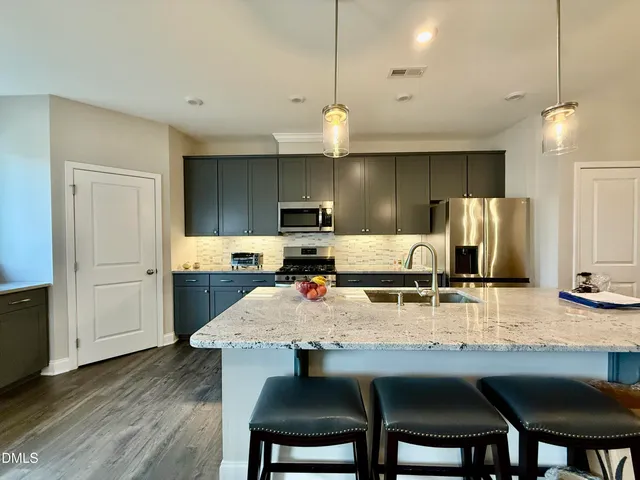 a kitchen with kitchen island granite countertop a table and chairs in it