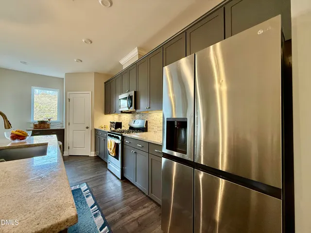 a kitchen with stainless steel appliances a refrigerator and a stove