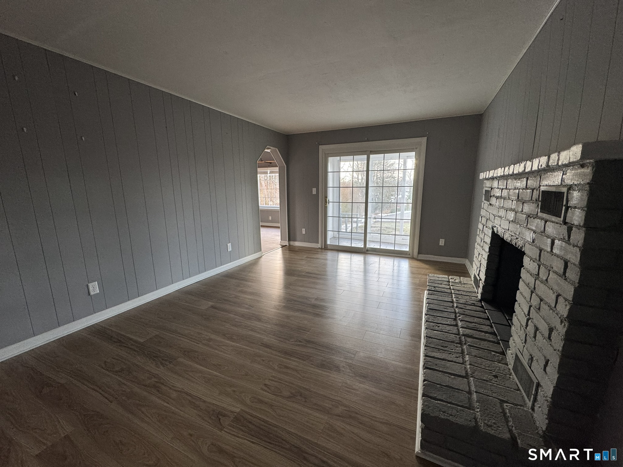 310 Lestertown Road Groton, CT 06340 - Photo 13 of 31 a view of an empty room with wooden floor and a fireplace