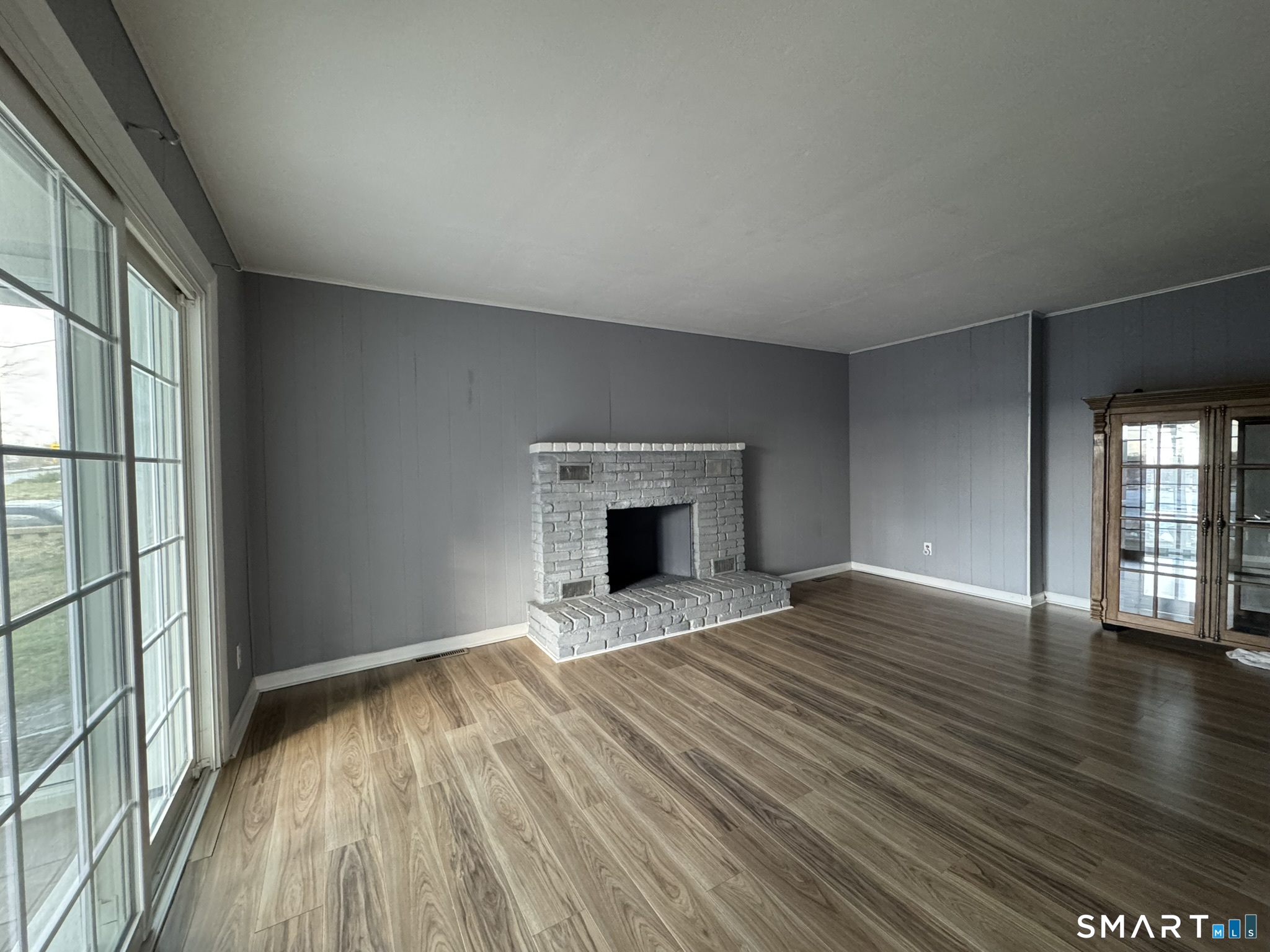 310 Lestertown Road Groton, CT 06340 - Photo 14 of 31 an empty room with wooden floor fireplace and windows