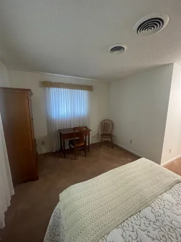a bedroom with a bed and a chair