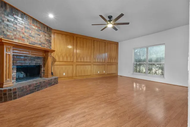 a view of an empty room with a fireplace and a window