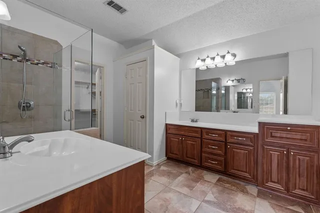 a spacious bathroom with a granite countertop sink a mirror a shower and a bathtub