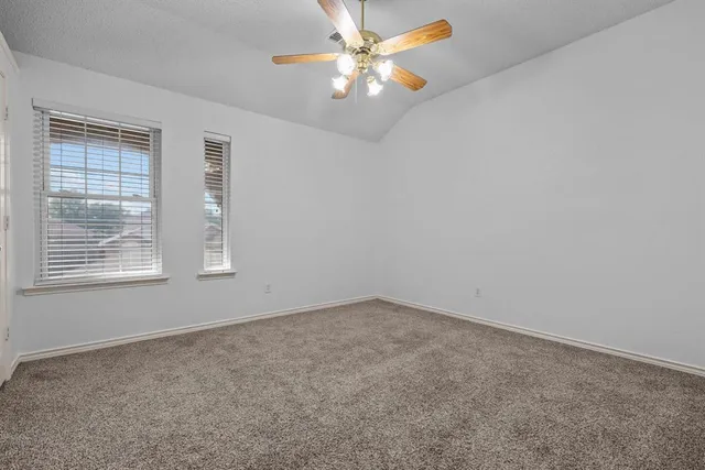 an empty room with windows and fan