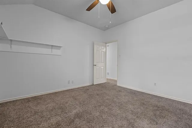an empty room with a ceiling fan and a window