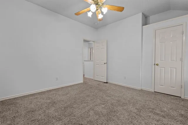 an empty room with chandelier fan