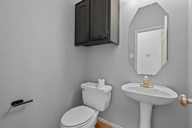 a bathroom with a toilet a sink and mirror