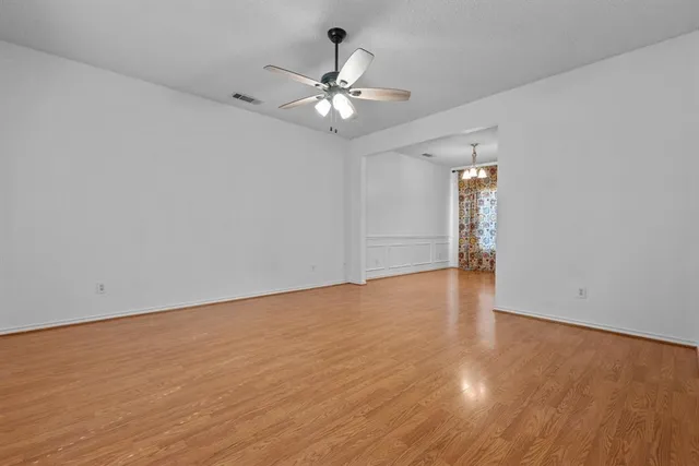a view of a room with wooden floor closet and a ceiling fan