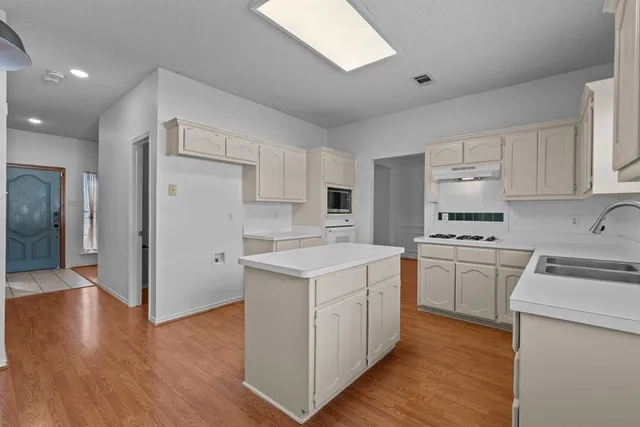 a kitchen with white cabinets stove and refrigerator