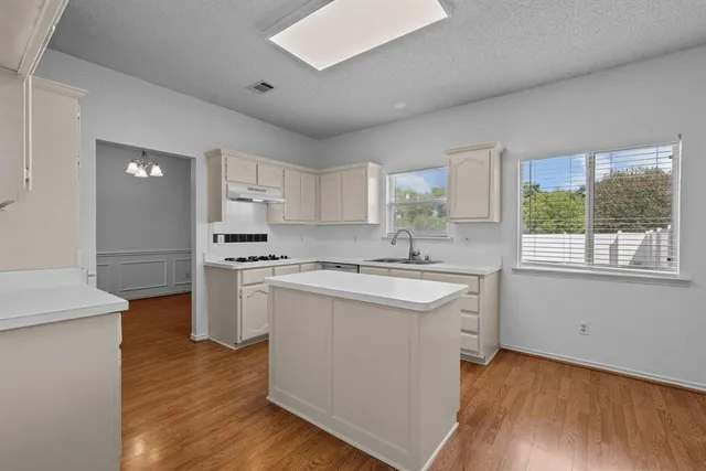 a kitchen with a sink cabinets stainless steel appliances and window