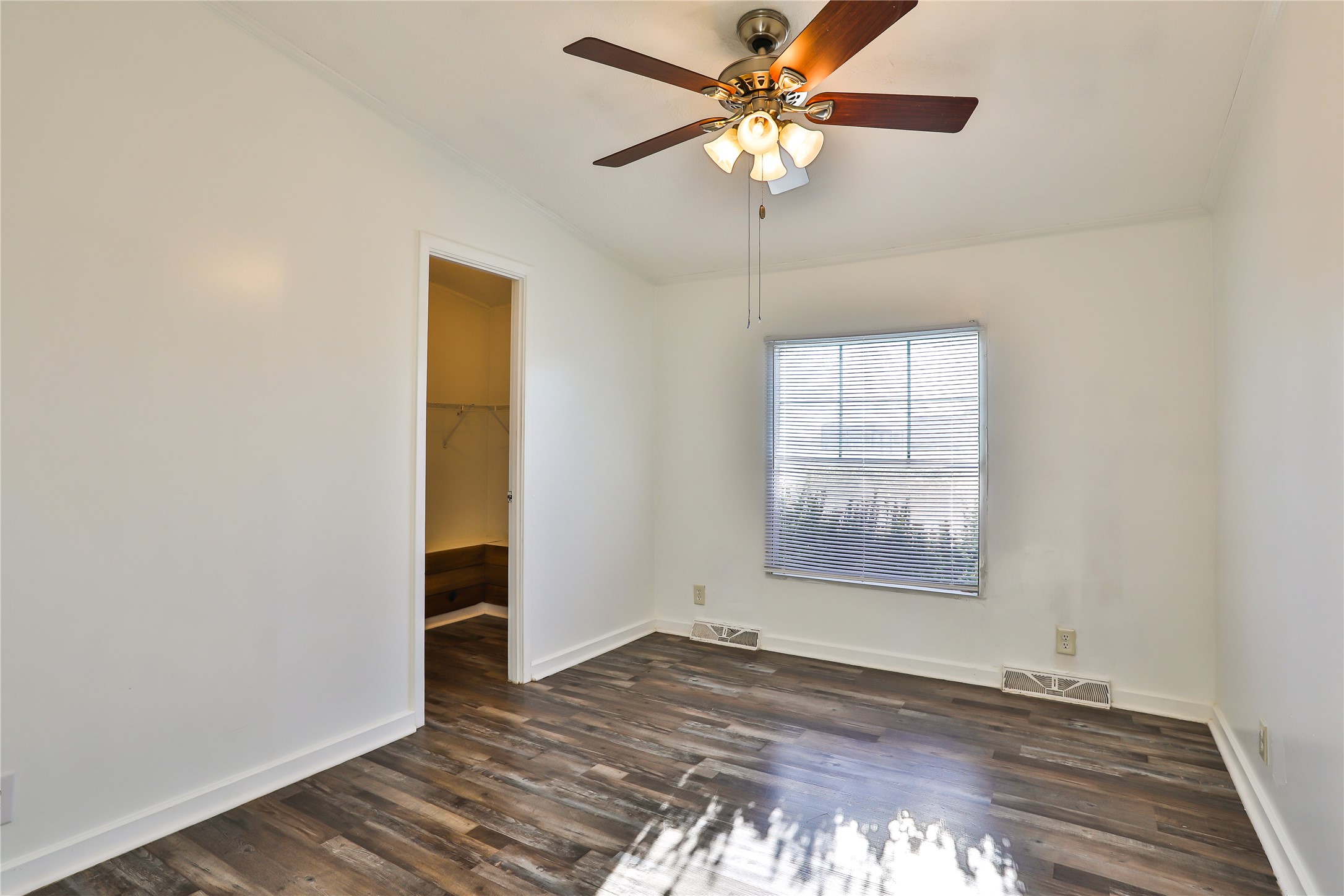 172 Kid Ranch Lane San Marcos, TX 78666 - Photo 13 of 29 Unfurnished bedroom featuring dark wood-style flooring, a ceiling fan, and a walk in closet