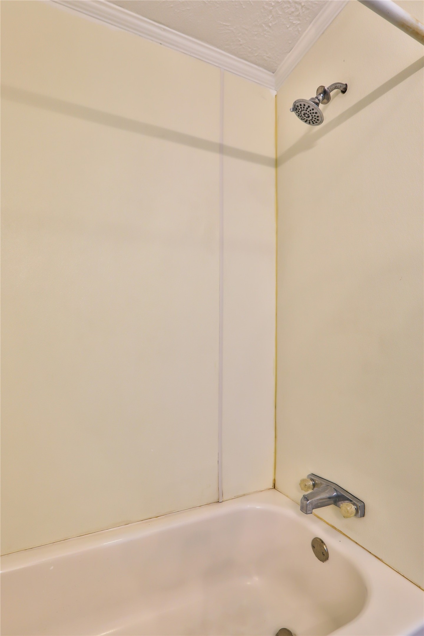 172 Kid Ranch Lane San Marcos, TX 78666 - Photo 18 of 29 Full bathroom featuring bathing tub / shower combination, a textured ceiling, and ornamental molding