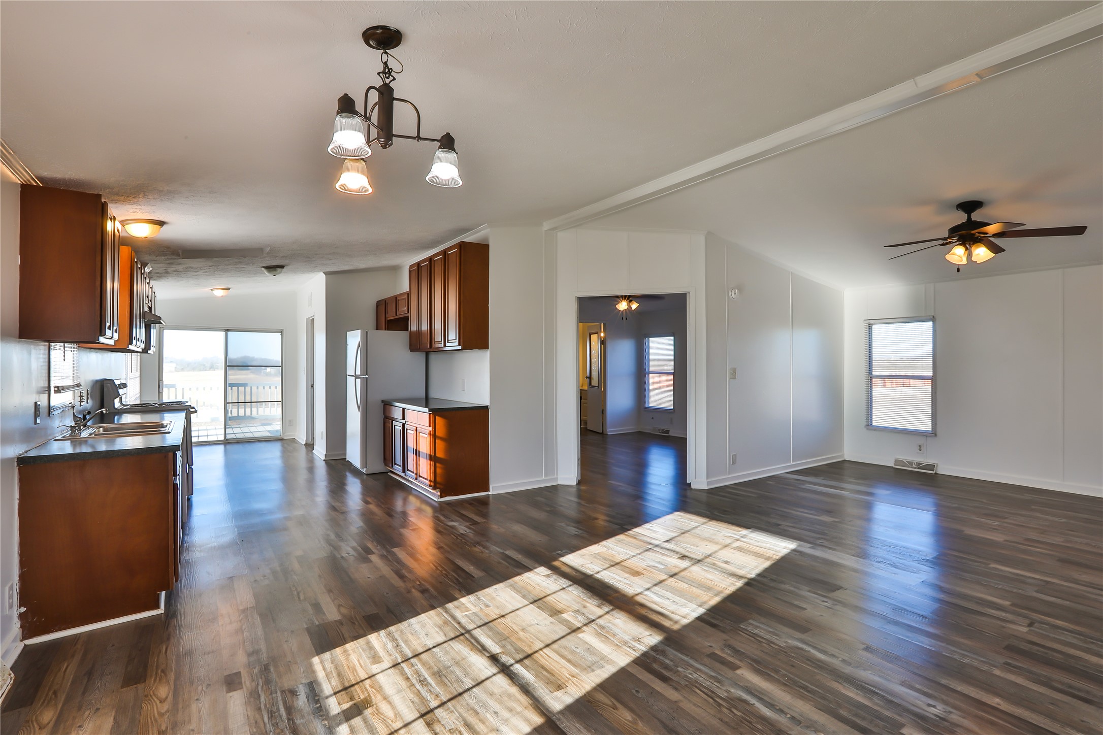 172 Kid Ranch Lane San Marcos, TX 78666 - Photo 29 of 29 Kitchen with open floor plan, wood finish cabinets, dark countertops, ceiling fan, and dark wood-style floors
