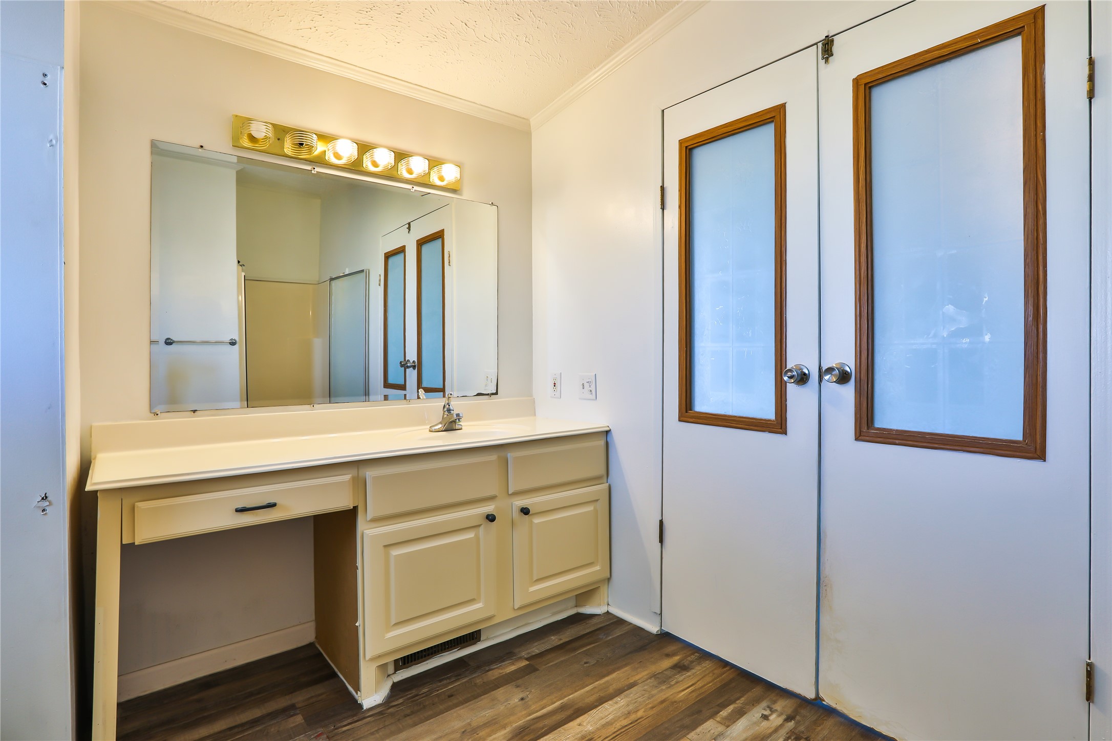 172 Kid Ranch Lane San Marcos, TX 78666 - Photo 24 of 29 Full bath with vanity, a textured ceiling, ornamental molding, dark wood-type flooring, and a shower