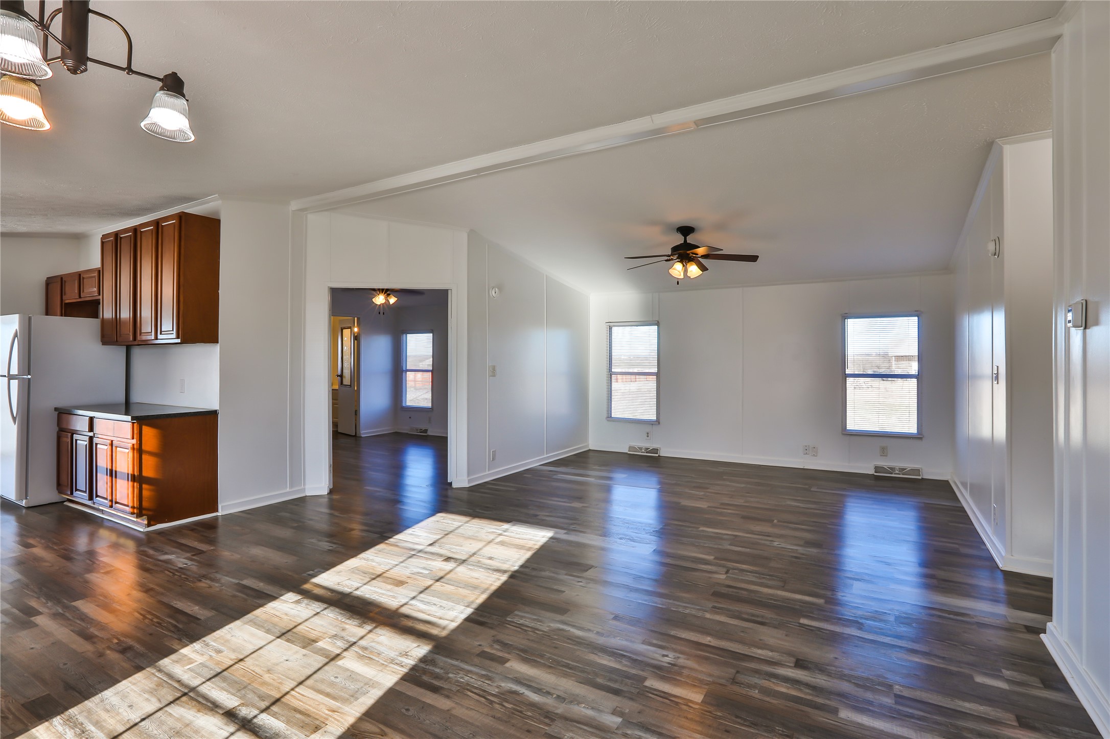 172 Kid Ranch Lane San Marcos, TX 78666 - Photo 2 of 29 Unfurnished living room featuring a ceiling fan, dark wood-type flooring, a chandelier, and lofted ceiling