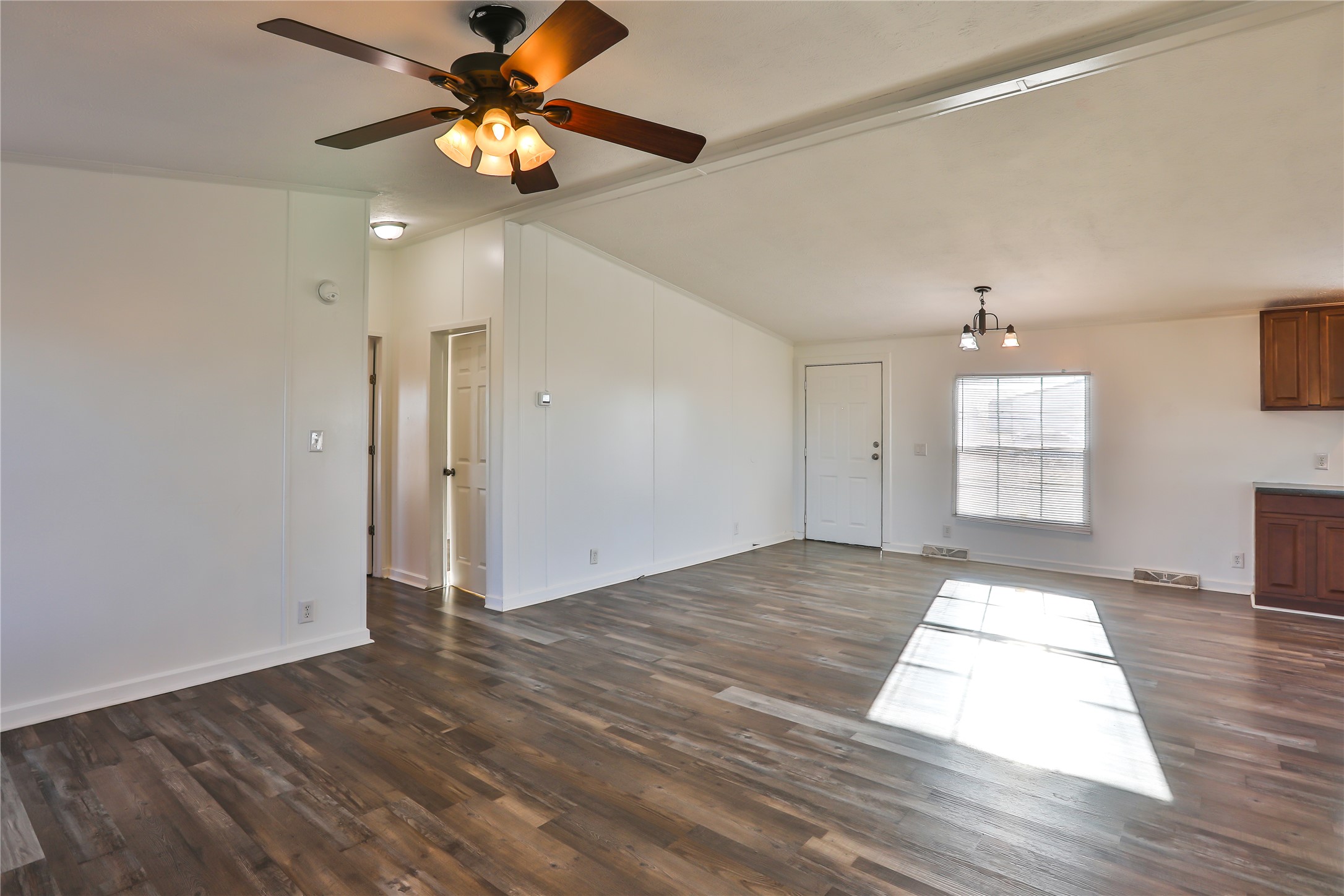172 Kid Ranch Lane San Marcos, TX 78666 - Photo 3 of 29 Unfurnished living room with dark wood finished floors, ceiling fan, a chandelier, and vaulted ceiling