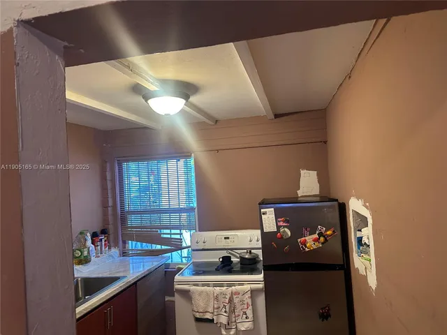 a kitchen with a refrigerator and a stove