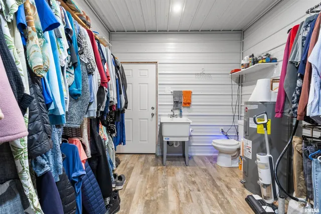 a view of walk in closet with clothes and shoes