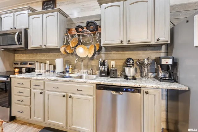 a kitchen with white cabinets and sink
