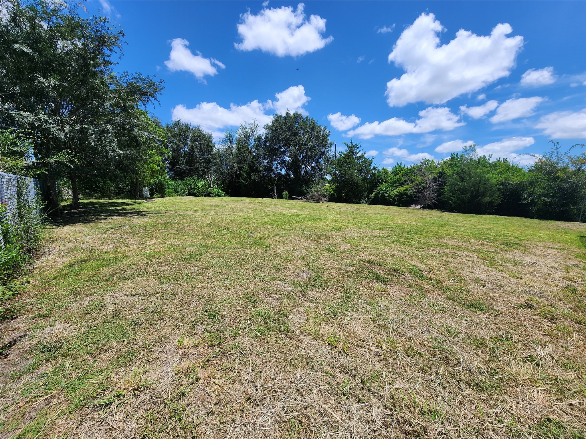 0 Rice Avenue Rosharon, TX 77583 - Photo 7 of 9 a view of a big yard with an outdoor space and trampoline