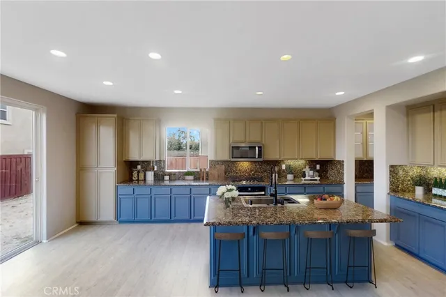 a kitchen with kitchen island granite countertop a sink and wooden cabinets