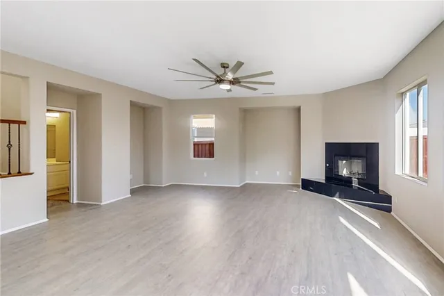 an empty room with fan and windows