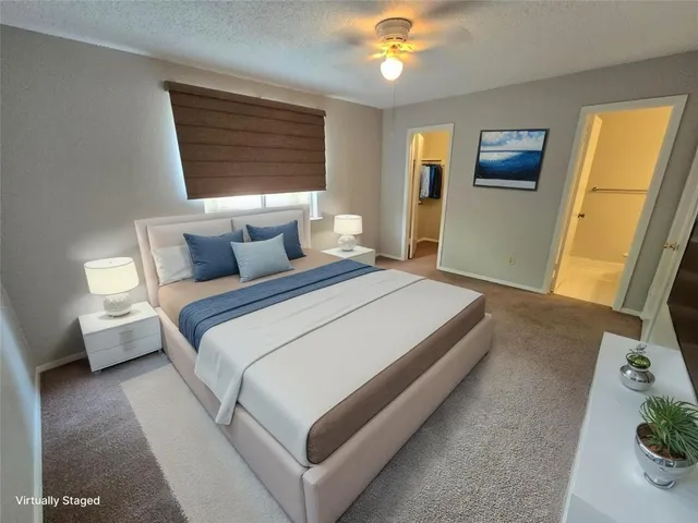 a bedroom with a bed lamp and a large window