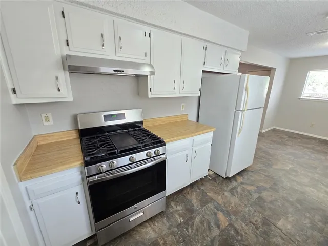 a kitchen with white cabinets and white appliances