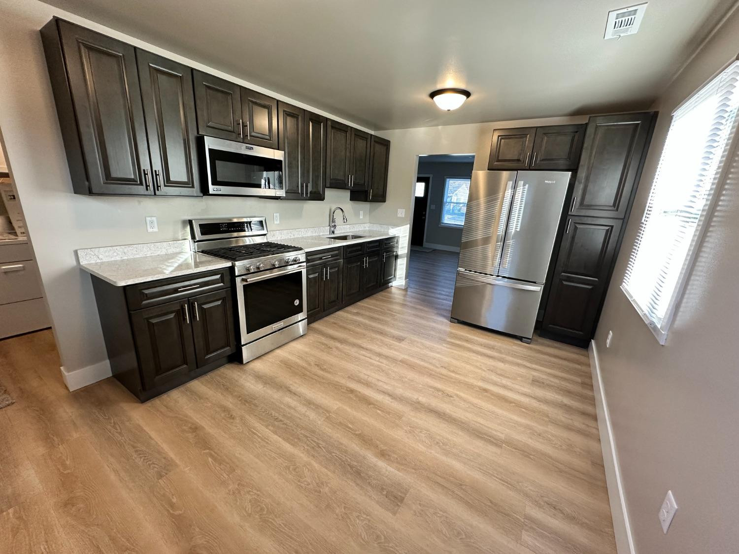 734-1 Imperial Road Valparaiso, IN 46385 - Photo 2 of 9 a kitchen with stainless steel appliances granite countertop a refrigerator a stove top oven a sink dishwasher and a refrigerator
