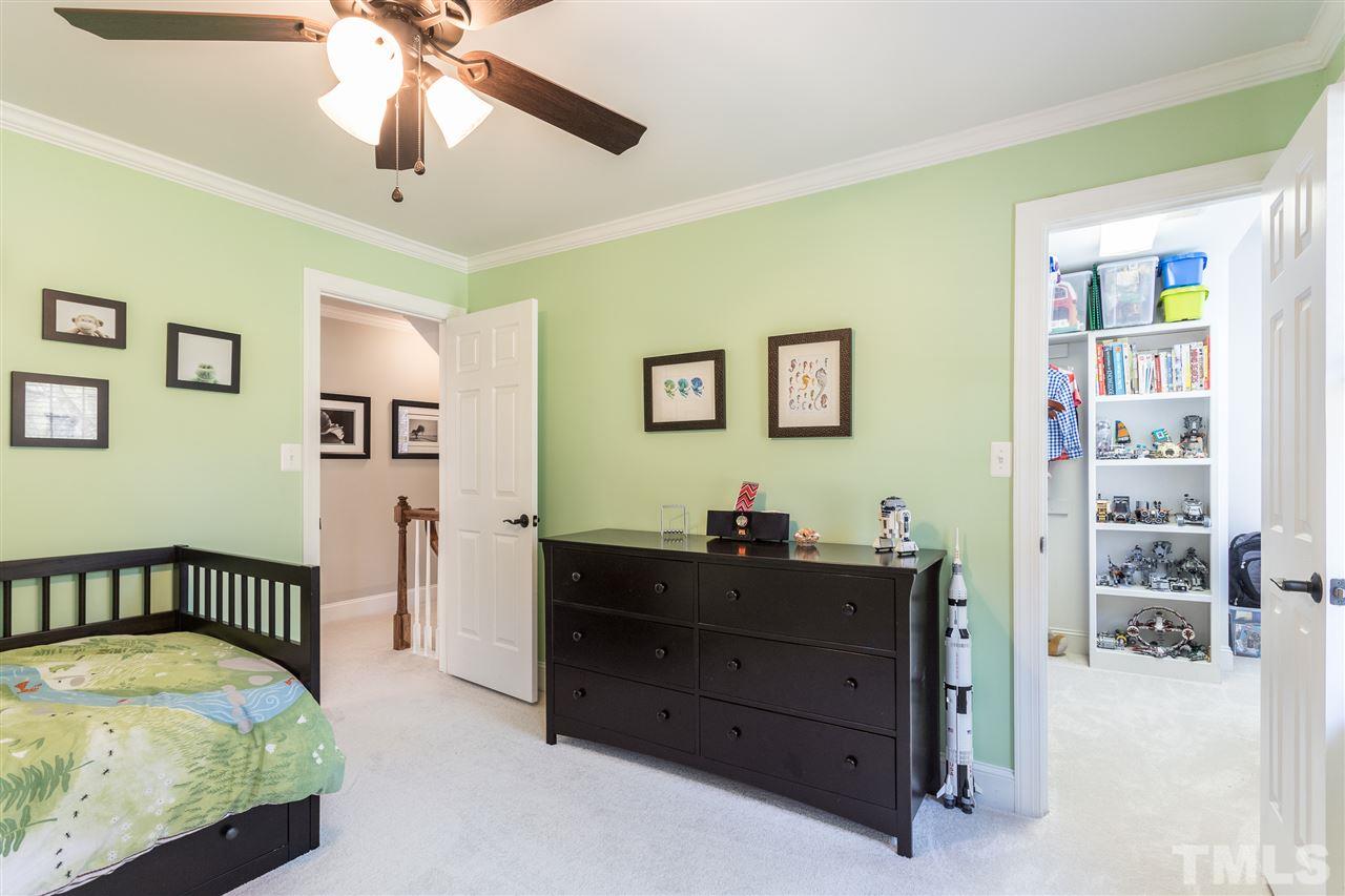 3020 Dunkirk Drive Raleigh, NC 27613 - Photo 14 of 18 a bedroom with a bed and a chandelier