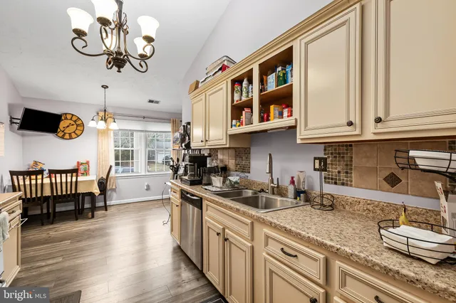 a kitchen with stainless steel appliances granite countertop a sink a stove and a wooden cabinets