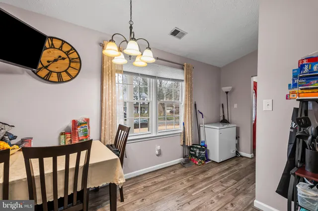 a view of a dining room with furniture wooden floor and a chandelier