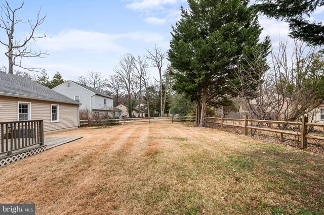 a view of a yard with wooden fence