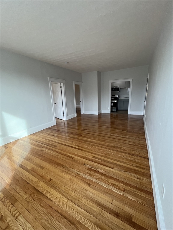 108 Bristol Road, Unit 1 Somerville, MA 02144 - Photo 11 of 24 a view of an empty room with wooden floor