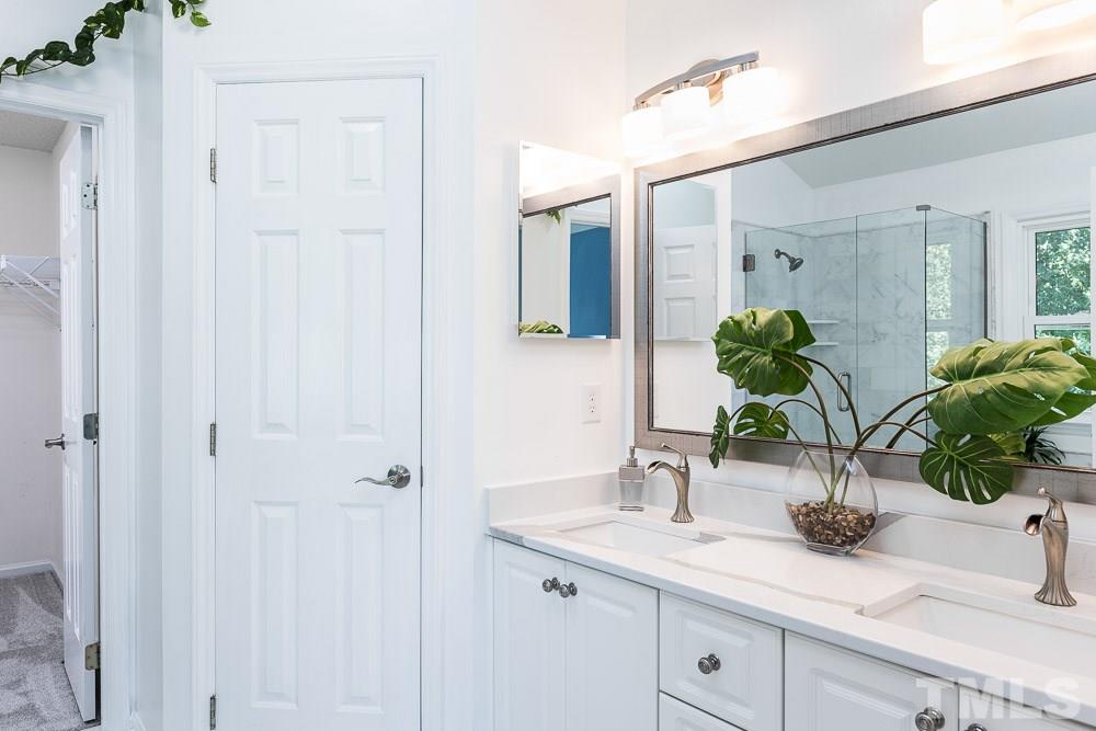 12212 Amoretto Way Raleigh, NC 27613 - Photo 16 of 30 a bathroom with a sink a vanity and a mirror
