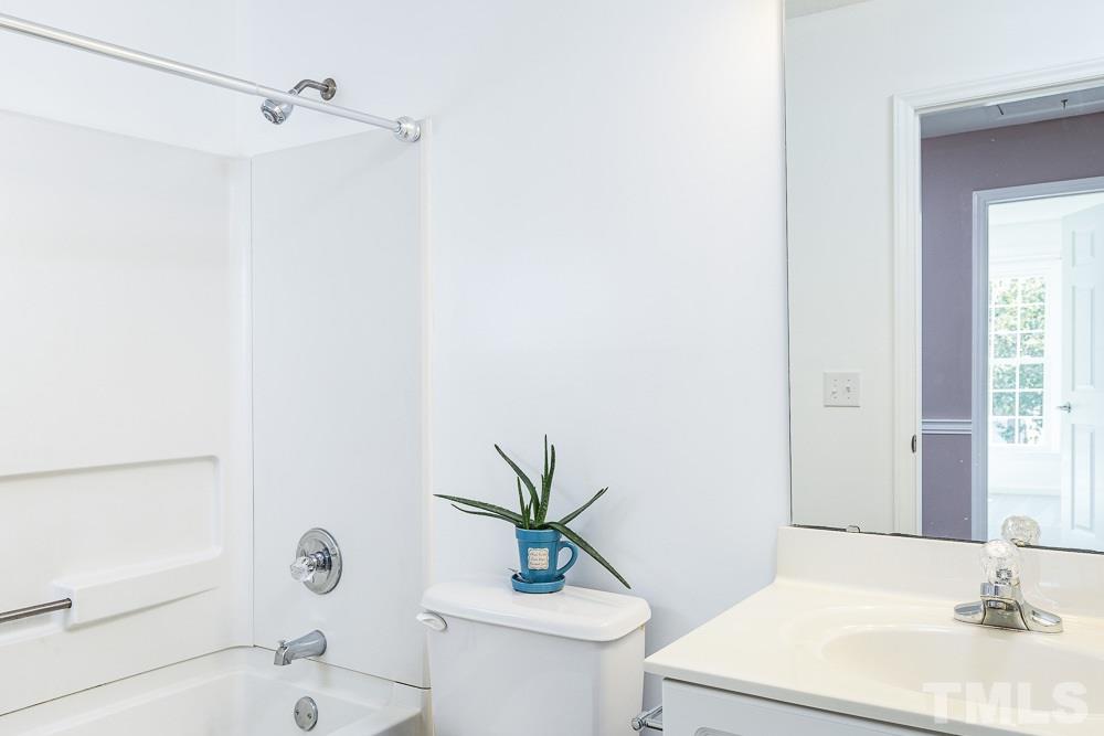 12212 Amoretto Way Raleigh, NC 27613 - Photo 22 of 30 a bathroom with a sink a toilet and shower