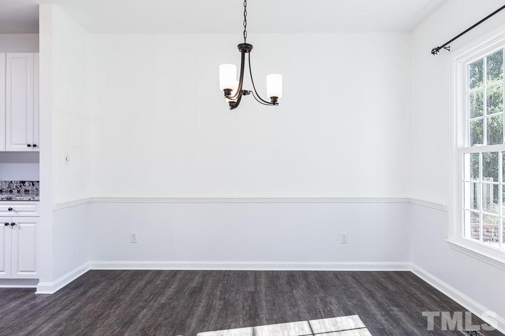12212 Amoretto Way Raleigh, NC 27613 - Photo 6 of 30 a view of a room with wooden floor and windows