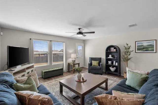 a living room with furniture a window and a flat screen tv