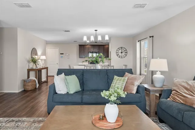a living room with furniture potted plant and wooden floor