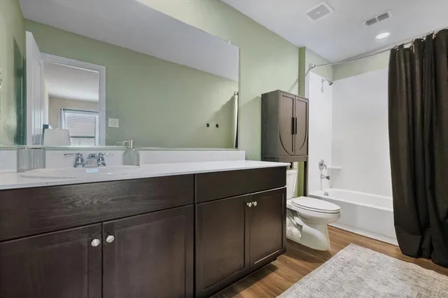 a bathroom with a double vanity sink toilet and shower