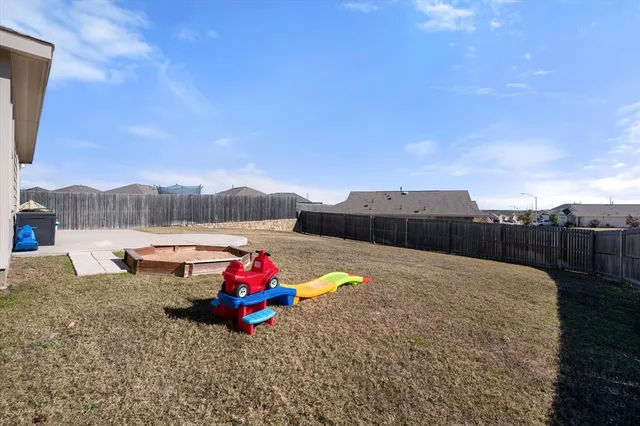 a backyard of a house with table and chairs