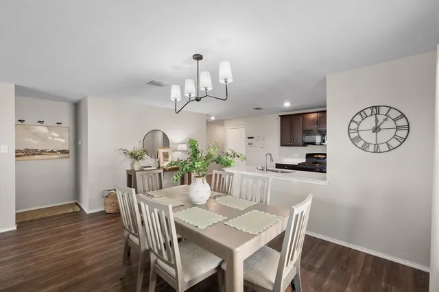 a view of a dining room with furniture a chandelier and wooden floor