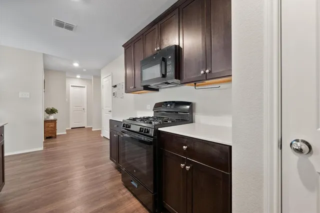 a kitchen with stainless steel appliances granite countertop a stove refrigerator sink and microwave