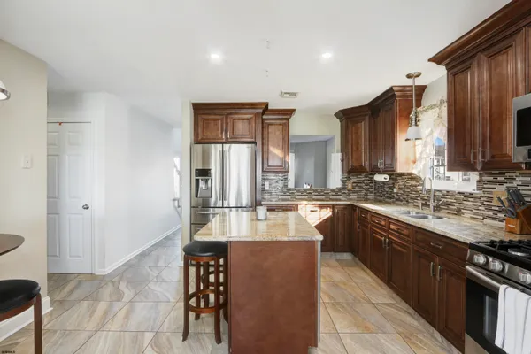 a large kitchen with kitchen island a sink stainless steel appliances and cabinets