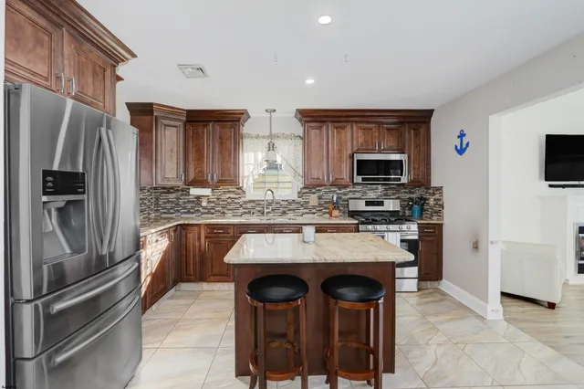 a kitchen with a refrigerator and a stove top oven