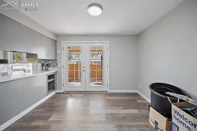 a kitchen with a refrigerator stove and wooden floor
