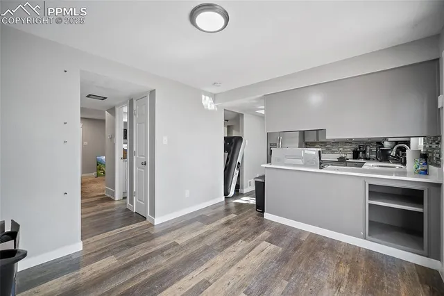 a kitchen with a refrigerator and white cabinets