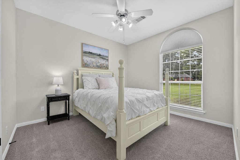 421 Ben Boyd Road Argyle, TX 76226 - Photo 13 of 25 Carpeted room featuring a large arched window, a ceiling fan with integrated lighting, neutral wall paint, and white baseboards